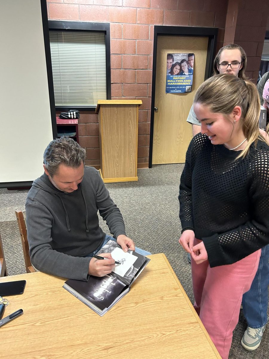 Jason Brubaker signs a copy of his book _Phobos_ for student Diana Teskey